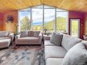 Comfortable living room with large windows offering scenic mountain views, complemented by cozy seating at 22155 Cook Ln, Morrison, CO 80465