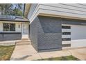 Modern home exterior with dark gray brick and white siding at 6403 Zang Ct, Arvada, CO 80004