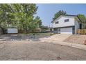 Two-story home with a gray and white exterior and landscaped yard at 6403 Zang Ct, Arvada, CO 80004