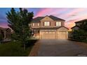 Two story home with an attached three car garage, lawn, and mature trees at 7606 S Valleyhead Ct, Aurora, CO 80016