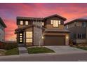 Beautiful two-story home with a two car garage, stone accents, manicured lawn and colorful sunset sky at 14710 Domino Dr, Parker, CO 80134