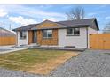 Stylish home with white brick, wooden accent, and landscaped front yard, presenting a welcoming and updated curb appeal at 9230 Aspen Dr, Thornton, CO 80229