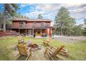 Large backyard featuring a fire pit, patio, and beautiful landscaping at 33844 Oriole Ct, Elizabeth, CO 80107