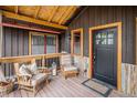 Cozy covered front porch with seating, lantern, and wooden accents at 33844 Oriole Ct, Elizabeth, CO 80107