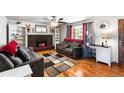 Cozy living room with a fireplace, built-in shelves and hardwood floors at 6336 W 71St Pl, Arvada, CO 80003