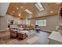 Inviting living room with hardwood floors, skylights, and comfortable leather seating at 1540 Fawnwood Rd, Monument, CO 80132