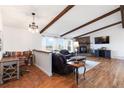 Bright living room featuring wood beams, a stone fireplace, and hardwood floors at 1604 Lisbon Dr, Parker, CO 80138
