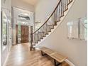 Bright foyer features hardwood floors, high ceilings, and a staircase with wrought iron spindles at 714 Skywalker Pt, Lafayette, CO 80026