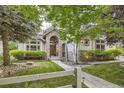 Charming home featuring a stone archway over the wooden front door, lush landscaping and mature trees at 714 Skywalker Pt, Lafayette, CO 80026