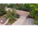Aerial view of a home with a spacious driveway and mature trees surrounding the property at 7140 S Uinta St, Centennial, CO 80112