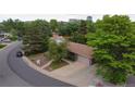 Aerial view of a home with a spacious driveway and mature trees surrounding the property at 7140 S Uinta St, Centennial, CO 80112