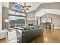 Living room with fireplace, hardwood floors, view of mountains, dining table, and comfortable couch at 33633 Elk Run, Evergreen, CO 80439