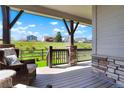 Relaxing covered patio with comfortable seating and views of the green landscape beyond the fenced yard at 8052 Mount Kataka St, Littleton, CO 80125