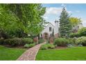 Well-maintained front yard showcasing lush landscaping, a stone path, and charming curb appeal at 5530 E 6Th Avenue Pkwy, Denver, CO 80220