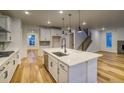 Bright, open kitchen featuring a large center island, quartz countertops and modern pendant lighting at 8465 Silverton Ln, Littleton, CO 80125