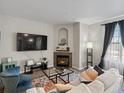 Comfortable living room features a corner fireplace, neutral walls, and a large television for cozy nights in at 5726 N Genoa Way # 201, Aurora, CO 80019