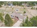 Aerial view of a charming gray single-Gathering home with a barn, shed, and mature trees at 1233 Starling Ln, Elizabeth, CO 80107