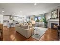 Spacious open-concept living room with hardwood floors, fireplace, and an adjacent modern kitchen at 6705 S Catawba Way, Aurora, CO 80016