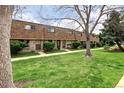View of a row of brick townhouses with landscaped lawns and mature trees at 13017 W 20Th Ave, Golden, CO 80401