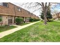 View of a row of brick townhouses with landscaped lawns and mature trees at 13017 W 20Th Ave, Golden, CO 80401