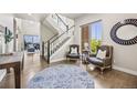 Bright foyer featuring hardwood floors, a staircase with black wrought iron spindles, and stylish decor with elegant seating at 10401 Maplebrook Way, Highlands Ranch, CO 80126