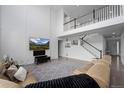 Spacious living room featuring a high ceiling, a staircase, and a comfortable sofa at 4792 Coltin Trl, Castle Rock, CO 80104