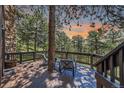 Relax and enjoy serene views on this home's deck, surrounded by lush greenery at 30722 Eldora Ct, Evergreen, CO 80439