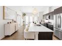 Open-concept kitchen with stainless appliances, a large island, and hardwood floors at 4395 Zuni St, Denver, CO 80211