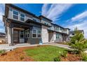 Contemporary townhomes showcasing gray siding, stone details, and well-maintained landscaping at 5773 N Jericho Way, Aurora, CO 80019