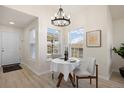 Bright dining area with a modern chandelier and views from two large windows at 12820 Ironstone Way # 301, Parker, CO 80134
