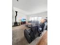 Cozy living room with a wood-burning stove, plush seating, and natural light at 58117 E 42Nd Dr, Strasburg, CO 80136