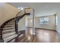 Elegant foyer features a curved staircase, hardwood floors, and abundant natural light from a large window at 22911 E Euclid Cir, Aurora, CO 80016