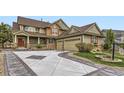 Beautiful two-story home with a three-car garage, stone accents, and a well-manicured front yard at 22911 E Euclid Cir, Aurora, CO 80016