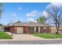 Ranch home features a brick exterior, mature trees, attached garage, and a well-manicured lawn at 2792 S Stuart St, Denver, CO 80236