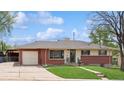 Charming brick home with well-maintained lawn, attached garage and mature trees at 2792 S Stuart St, Denver, CO 80236