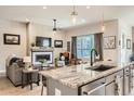 Open-concept living space featuring a fireplace, large window, and seamless flow into the kitchen, perfect for modern living at 21985 E Bailey Pl, Aurora, CO 80016