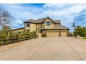 Exterior elevation of the rear of home showcasing an expansive three car garage and fenced yard at 6391 S Malaya St, Centennial, CO 80016