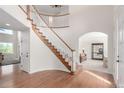 Welcoming foyer with gleaming wood floors, curved staircase, and arched doorway to living room at 6391 S Malaya St, Centennial, CO 80016