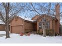 Attractive brick and wood exterior home with a two-car garage, nestled amongst trees at 7900 E Dartmouth Ave # 76, Denver, CO 80231