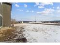 Snowy backyard with open space and distant views of houses at 996 Kolz Pt, Elizabeth, CO 80107