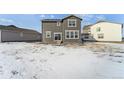 Snowy backyard view of house with distant homes visible at 996 Kolz Pt, Elizabeth, CO 80107