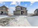 Two-story house with gray siding, attached garage, and snowy front yard at 996 Kolz Pt, Elizabeth, CO 80107