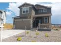 Two-story home featuring stone accents, a covered porch, an attached garage, and freshly landscaped front yard at 996 Kolz Pt, Elizabeth, CO 80107