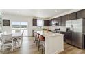 Bright kitchen featuring an island with bar seating, stainless steel appliances, and a sliding glass door to the outside at 996 Kolz Pt, Elizabeth, CO 80107