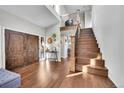 Bright entryway with hardwood floors, double doors, and elegant staircase at 6238 W 80Th Pl, Arvada, CO 80003