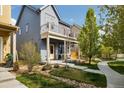 Beautiful home featuring a covered front porch, balcony, landscaped front yard, and walkway at 1702 W 66Th Ave, Denver, CO 80221