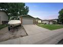 Single-Gathering home featuring a long driveway, two-car garage, boat, well-maintained lawn, and mature trees at 10462 Hoyt St, Westminster, CO 80021