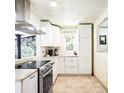 Bright kitchen featuring stainless steel appliances, granite countertops, and tile flooring at 2701 S Hazel Ct, Denver, CO 80236