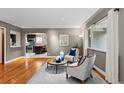 Bright living room featuring hardwood floors, modern furniture, and a view into the kitchen area at 760 Niagara St, Denver, CO 80220