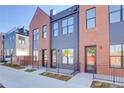 Street view of modern townhomes featuring brick and siding, complemented by sidewalk at 5142 W 44Th Ave, Denver, CO 80212